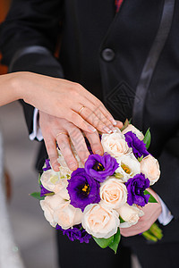 新郎和新娘的手放在婚礼花束上仪式犯罪戒指庆典已婚婚姻玫瑰生活男人订婚图片