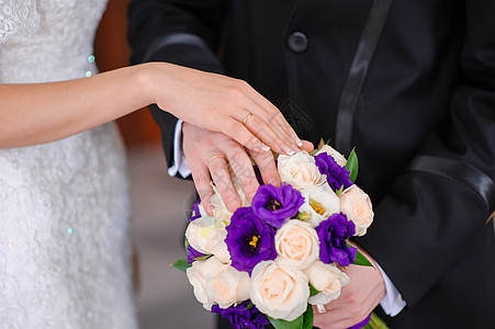 新郎和新娘的手放在婚礼花束上婚姻新人蜜月犯罪指甲已婚花朵戒指钻石庆典图片