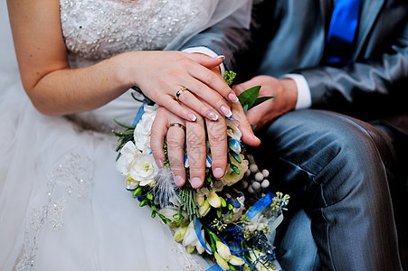 手放在婚礼花束上伙伴家庭蜜月丈夫夫妻玫瑰钻石接待庆典订婚图片