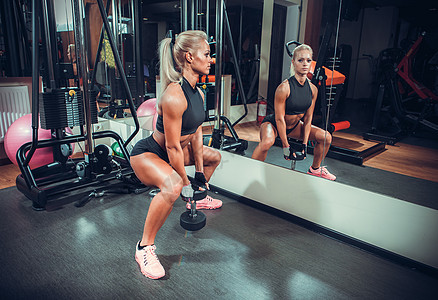 在健身房用哑铃打工的漂亮美女建筑腹部体操重量训练力量运动员肌肉女孩身体图片