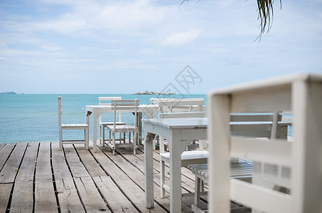 白椅子和白桌天空风景休息热带场景休息室海洋躺椅木头海岸线图片
