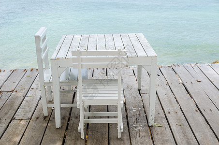 白椅子和白桌长椅海岸线海洋木头天堂桌子闲暇场景支撑休息图片