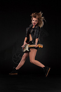 美丽的女孩弹吉他摇杆金属流行音乐音乐头发专注热情女性娱乐皮夹克图片
