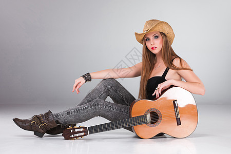 那个戴着牛仔帽和音响吉他 美丽的女孩青少年乐器音乐家爱好歌手音乐岩石灰色女士牛仔图片