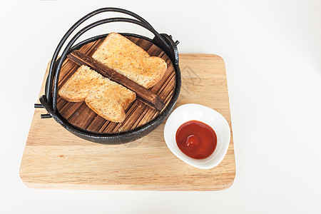 烤黑铁碗吐司和木盘番茄酱图片