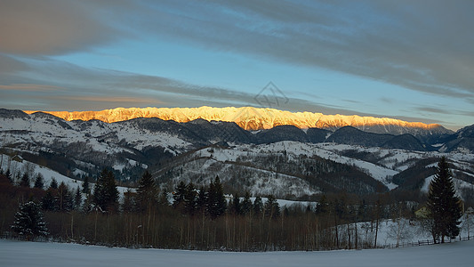 日落时的山森林季节冻结爬坡山腰晴天天空白色粉色图片