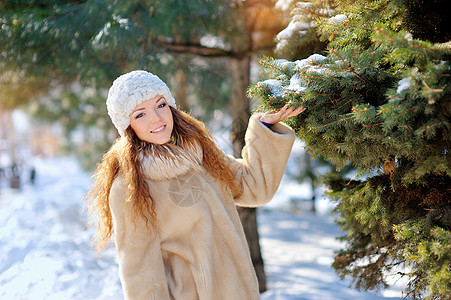 冬天圣诞树附近街道上的漂亮女孩背景图片