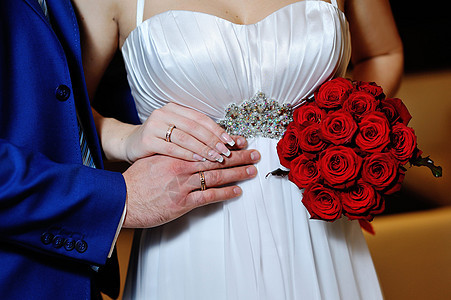 把新娘和新郎的手 举着结婚戒指图片