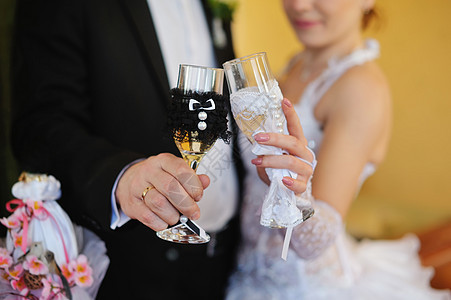 怀着美丽的婚礼香槟杯的新娘和新郎图片