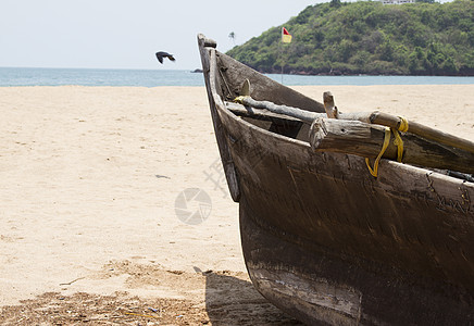 印度果阿岛印度沙滩上的老鱼船海浪热带异国地平线支撑阳光海滩场景太阳港口图片