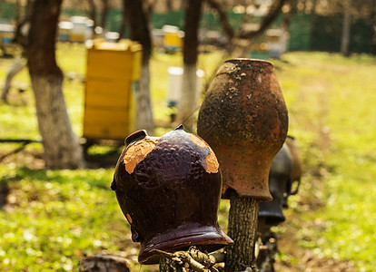 旧的传统粘土罐挂在木栅栏上蜂房红陶黏土花瓶文化手工投手陶器乡村水壶图片