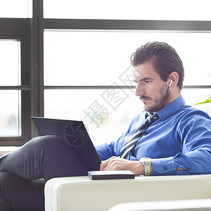 在办公室的商务人士 在他的笔记本电脑上工作衬衫监视器男人智能员工耳机手机职业企业家技术图片