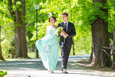 结婚夫妇在公园散步庆典婚姻情感套装小路花朵婚礼快乐女性裙子图片