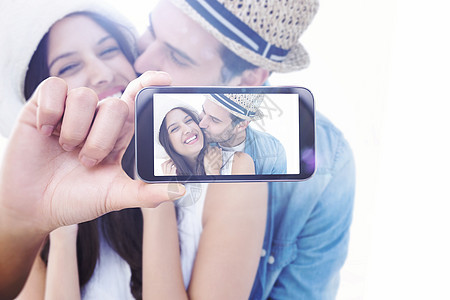 手持智能手机显示的复合图象脸颊夫妻休闲服装草帽男人电话女性微笑技术图片