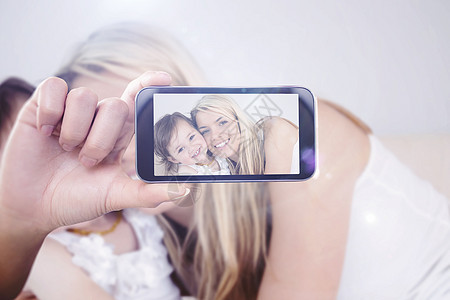 手持智能手机显示的复合图象幸福微笑金发头发女孩自拍屏幕棕色公寓技术图片