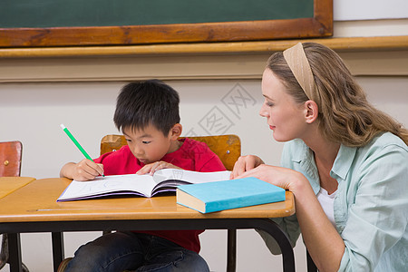 教师在课堂帮助学生知识桌子瞳孔小学生学校班级职业童年椅子孩子图片