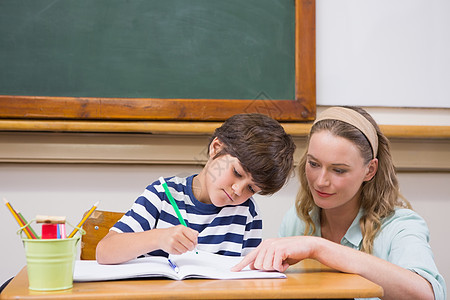 教师在课堂帮助学生学校桌子男生教学男性瞳孔早教孩子知识讨论图片