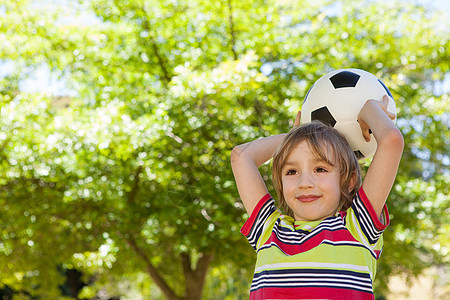玩足球的快乐小男孩绿色晴天投掷微笑绿地农村环境阳光公园男性图片