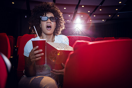 文艺演出年轻女性在看一部3D电影座位闲暇椅子玻璃杯时间演出电影院娱乐礼堂玻璃背景