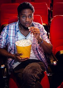 年轻人在看电影礼堂文艺黑色时间男人娱乐电影业座位手势双腿图片