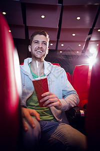 快乐的年轻人在看电影座位男人红色电影礼堂椅子电影院文艺活动演出图片