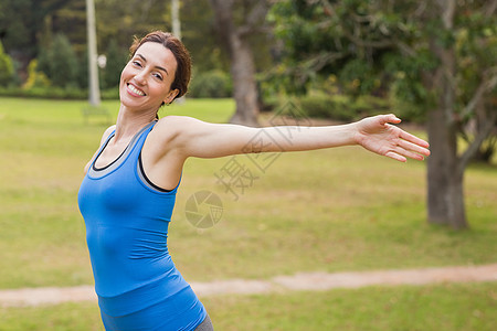 漂亮的黑发美女在慢跑时伸胳膊女士跑步运动调子乐趣竞技运动服女性闲暇公园图片