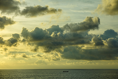 阴云的日落黄色海洋天空蓝色阳光戏剧性射线地平线图片