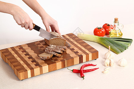 切割板上的产品菜板面包棕色木板植物油木头胡椒韭葱红色食物图片