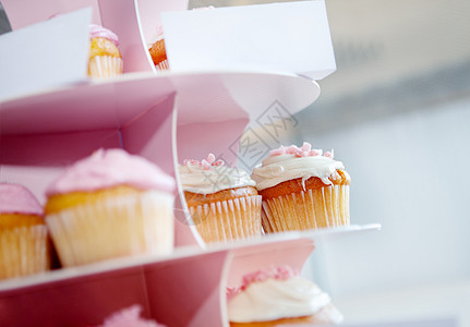 粉红纸杯蛋糕和巧克力 在蛋糕柜里加奶油图片