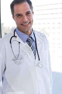 微笑的医生在看照相机保健专家医疗男性医院工作服医学职业专业男人背景图片