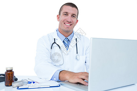 在笔记本电脑上工作的微笑医生医务室诊所从业者桌子服务办公室男人男性专家快乐图片