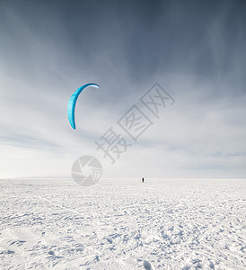 雪上放着蓝风筝的滑板机天空自由空气追求危险段落蓝色闲暇跳跃男性图片