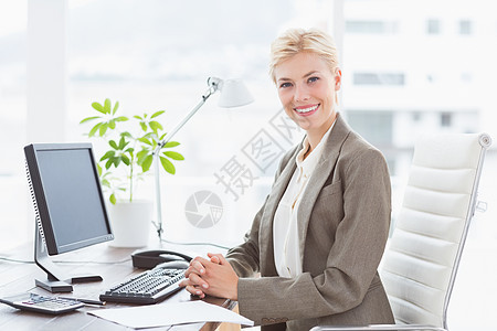 微笑的女商务人士看着相机桌子女性女士快乐电话技术头发短发电脑笔记图片