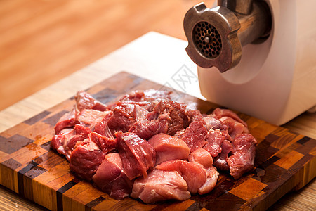 电动肉研磨机和切肉斧头动物红色猪肉木头牛肉厨房烹饪桌子食品图片