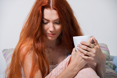 在床上喝早咖啡的双层妇女女士休息杯子思维沉思品味饮料长发享受女孩图片