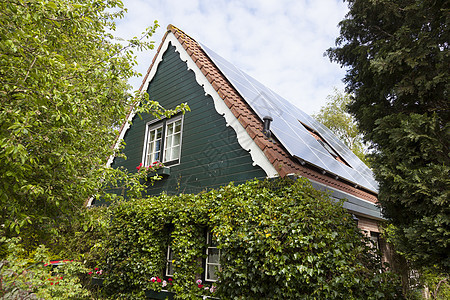 带有木头和太阳能电池板的传统杜丘房屋力量技术财产窗户艺术建造阳光晴天天空控制板图片