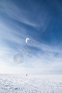 雪上放着蓝风筝的滑板机假期气候危险太阳追求活动男性闲暇阳光飞行图片