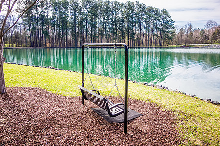 俯视湖或池塘的空木制公园长椅图片