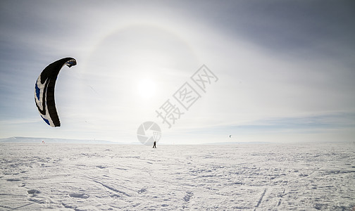 雪上放着蓝风筝的滑板机男性旅行天空力量冒险闲暇跳跃飞行活动危险图片