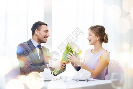 男人笑着在餐厅送花束周年庆典花朵礼物纪念日女士眼镜展示男性男朋友图片