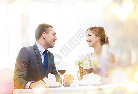 男人笑着在餐厅送花束丈夫幸福周年庆典男性男朋友订婚郁金香花朵女朋友图片