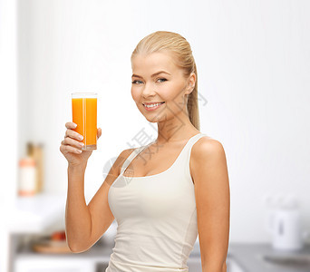 带着橙汁杯子的笑着女人玻璃饮食房间厨房快乐衬衫活力身体橙子水果图片