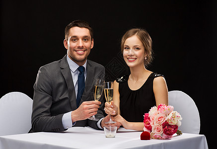 一对夫妇在餐厅 喝香槟的杯子纪念日女朋友礼物盒子女士订婚微笑男人眼镜花束图片