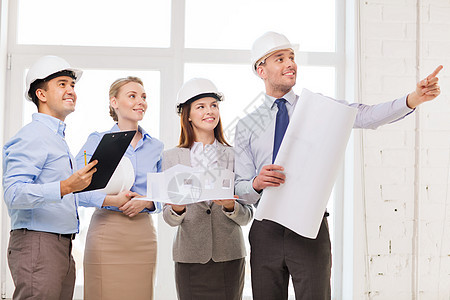 办公室中快乐的商务团队安全帽伙伴训练男人头盔工人蓝图建造女性团体图片