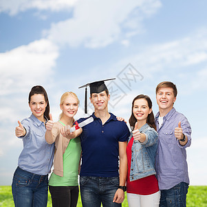 具有显示大拇指的文凭的学生群体天空快乐大学团队女孩们角帽学校知识教育学士图片
