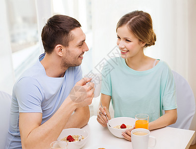 喝果汁的情侣在家吃早餐时微笑的情侣妻子厨房食物恋人家庭面包牛奶幸福女士果汁背景