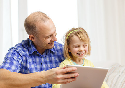 拥有平板电脑的幸福父亲和女儿童年闲暇游戏家庭微笑技术父母开支阅读视频图片