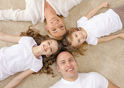 父母和两名女孩躺在家中的地板上说谎幸福女性母性微笑男人女儿家庭父亲青春期图片