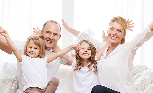 双亲和两个小女孩在新家里笑着妈妈成人房子父母房间母亲快乐父亲幸福孩子图片