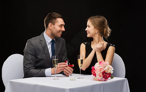 男人向在餐厅的女朋友求婚的男人未婚妻生日首饰礼物钻石花朵盒子庆典未婚夫惊喜图片